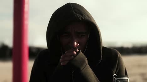 man holding his hands by his mouth on the beach