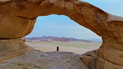 aerial view of wadi rum with woman standing in the desert in jordan - drone shot