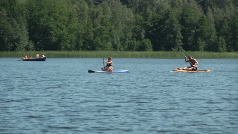 men  and woman with sup boards at lake. forest  background. hot sunny summer day.