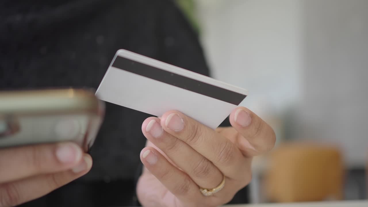 Close-up of Hands Holding Credit Card and Smartphone for Online Payment