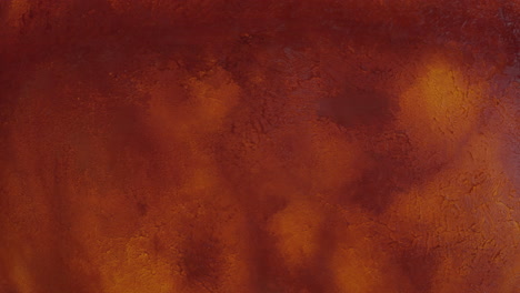 abstract textured surface resembling a red planet landscape.