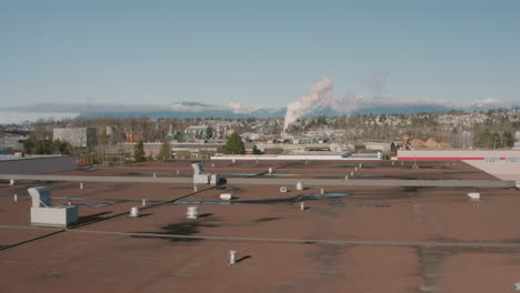 Aerial-rising-over-a-building-to-to-reveal-the-Richmond,-BC-landscape