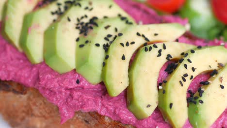 tostada de aguacate con hummus de remolacha y semillas de sésamo negro