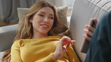 joyful woman videocalling smartphone laying home sofa closeup. girl virtual call