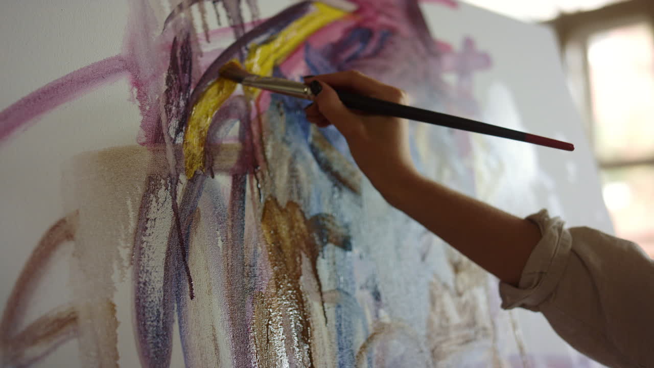 mujer joven dibujando en el lugar de trabajo. pintora creativa haciendo pinceladas en el interior.