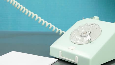the hand picks up the phone and writes down the number with a pen.
