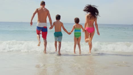 Happy-family-running-towards-waves