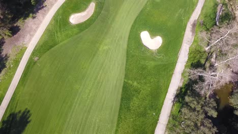 4k panning birds eye view of a fairway and green on a golf course in los, angeles, california on a warm sunny day with breathtaking views