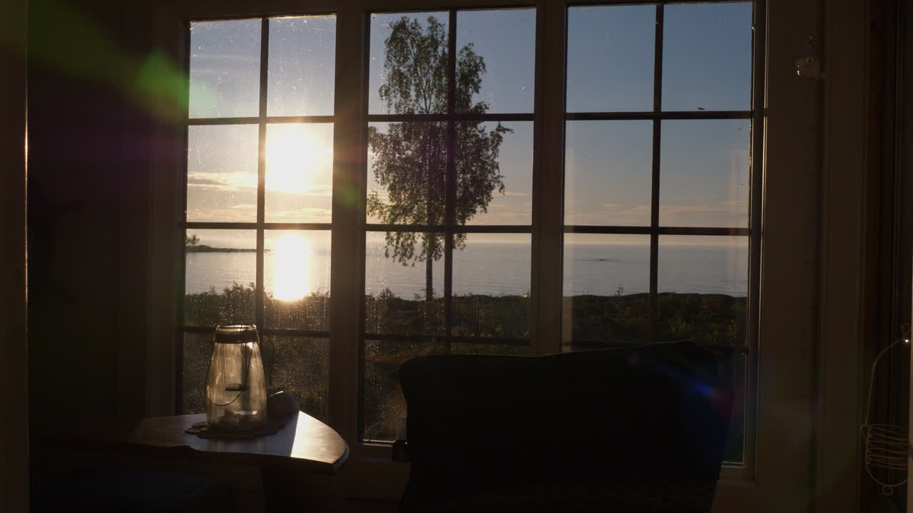 바다 옆 오두막 내부에서 일몰의 핸드헬드 중간 샷