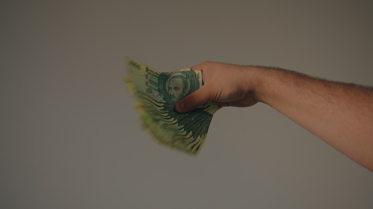 hombre sacudiendo una gran cantidad de 100.000 billetes de guarani, un signo de abundancia y felicidad