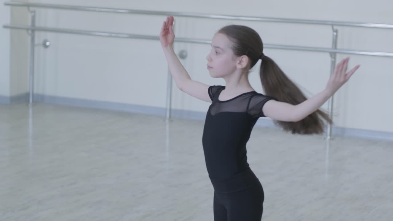 Young Ballerina Practicing Dance Moves in Studio