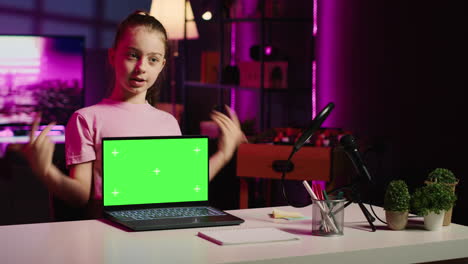 niño influyente en el estudio casero usando equipo de grabación para grabar la revisión de la maqueta de computadora portátil
