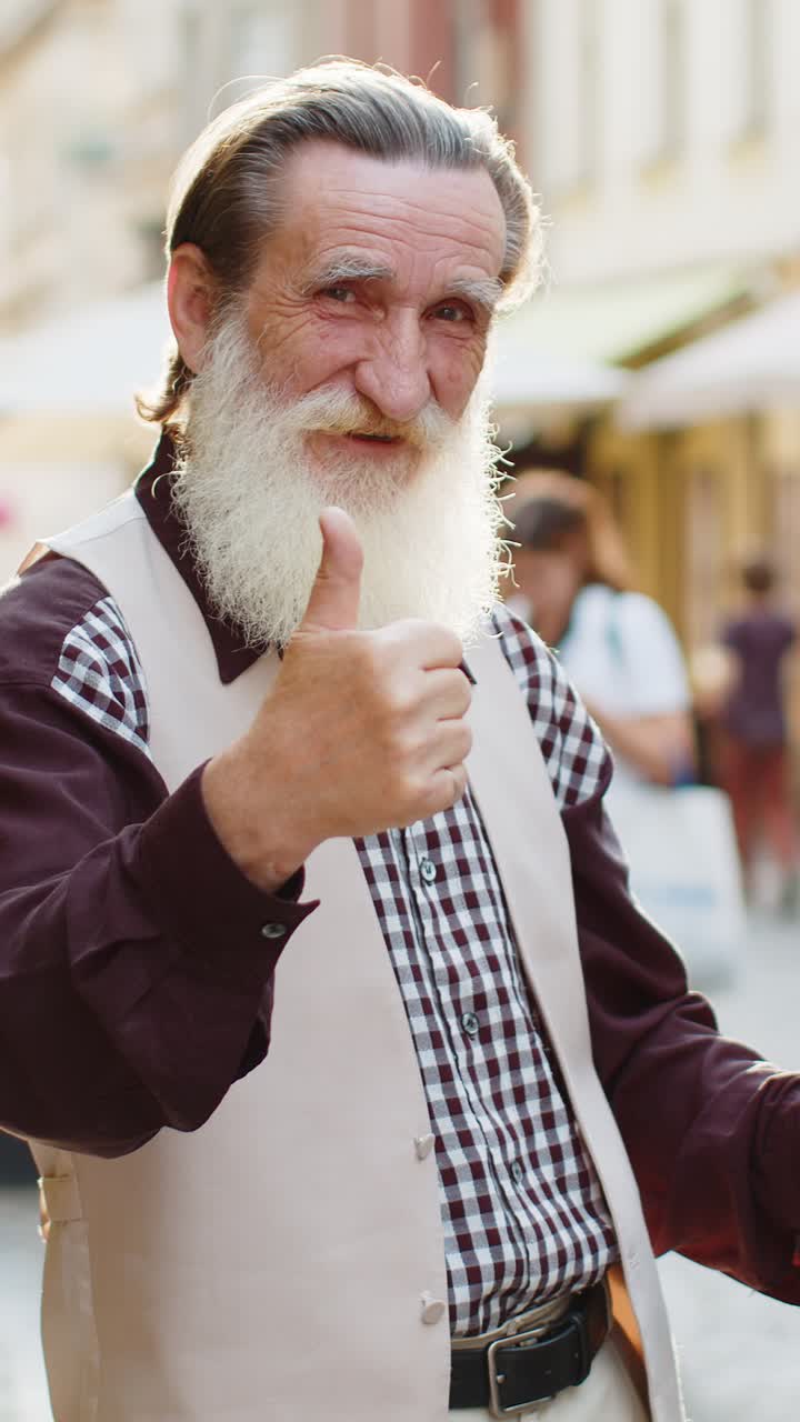 Happy old man showing thumbs up like sign positive something good positive feedback in city street