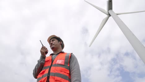 progressive engineer working with the wind turbine, with the sky as background.