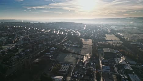 cold winter morning aerial footage of a town city landscape, with low afternoon lighting and freezing sunlit houses
