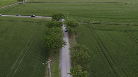 Malerische-Roadtrip-Durch-Grüne-Felder-Mit-Luftaufnahme-Hinter-Dem-Auto-Und-Wehendem-Wind