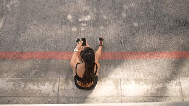 Vista dall'alto di donna afroamericana che usa il cellulare in città 4k