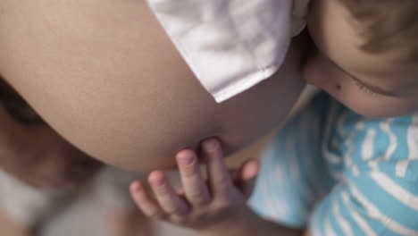 boy hugging his mother pregnant belly