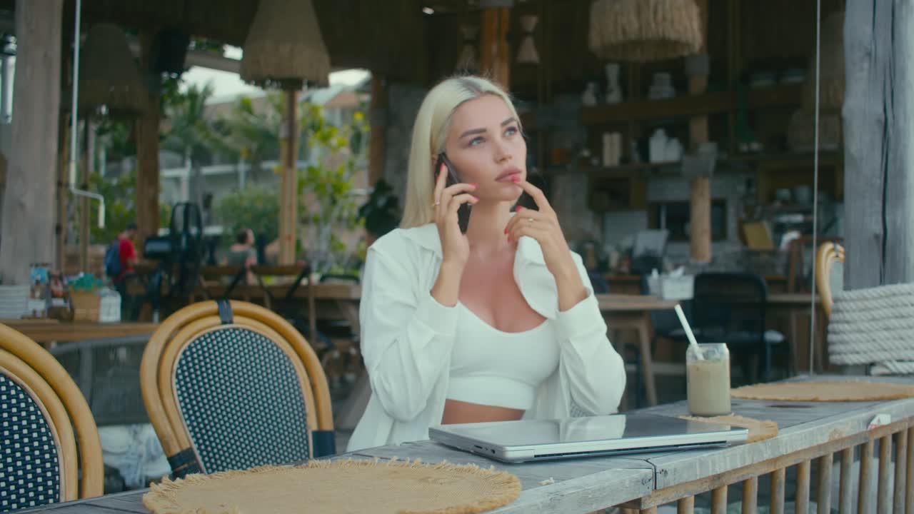 Woman working on laptop in a beach cafe
