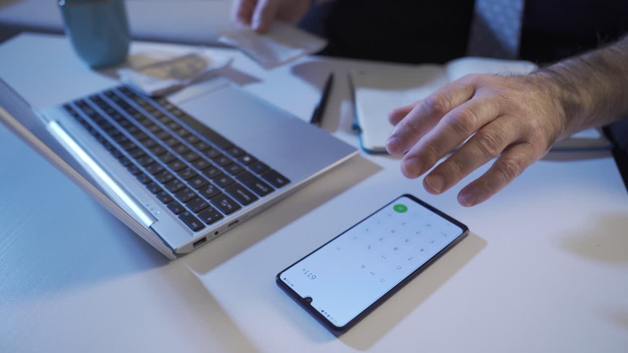 hombre trabajando calculando el presupuesto del hogar. hombre calculando el presupuesto del hogar con la calculadora por la noche en casa.