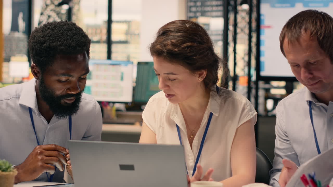 Team collaboration in a corporate office environment with laptop and reports