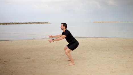 Morning-at-the-seaside-and-adult-male-doing-squat-exercises-to-stay-fit-and-healthy