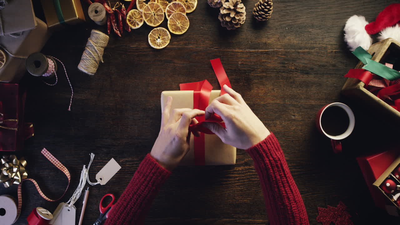 vista superior manos envolviendo regalos de navidad en un escritorio de madera desde arriba - dragón épico rojo