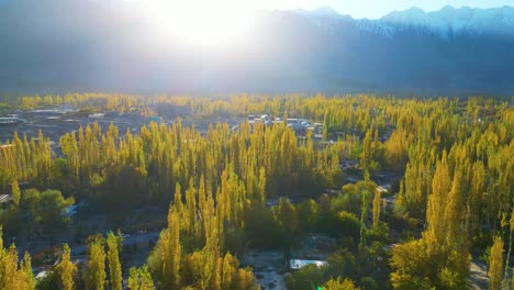 skardu valley with snowcapped mountain range in background in sunny daylight, aerial view