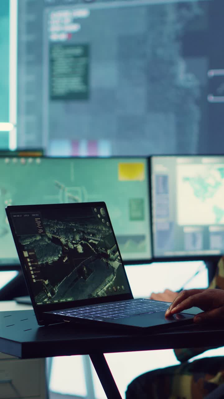 Person Using Laptop for Satellite Surveillance in Control Room