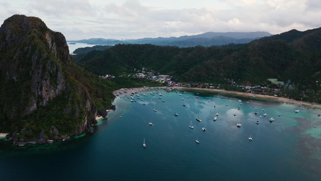 Những chiếc thuyền du lịch neo đậu trong vịnh El Nido yên bình dưới những vách đá vôi ở Palawan.