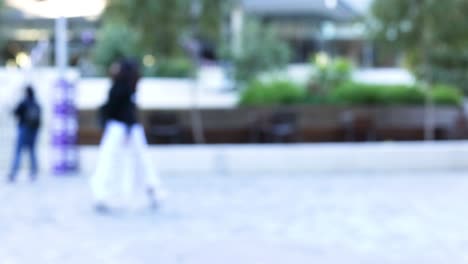 blurry figures walking in a public square