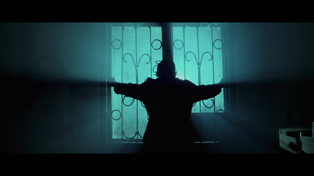 Silhouette of a Person at a Window at Night