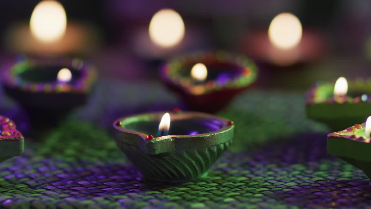 velas encendidas en ollas de arcilla decorativas en alfombra de mesa tejida, enfoque en primer plano, fondo bokeh