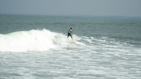 surfer surfing waves on bali beach in sunny