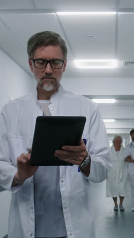 médico usando una tableta en el pasillo del hospital