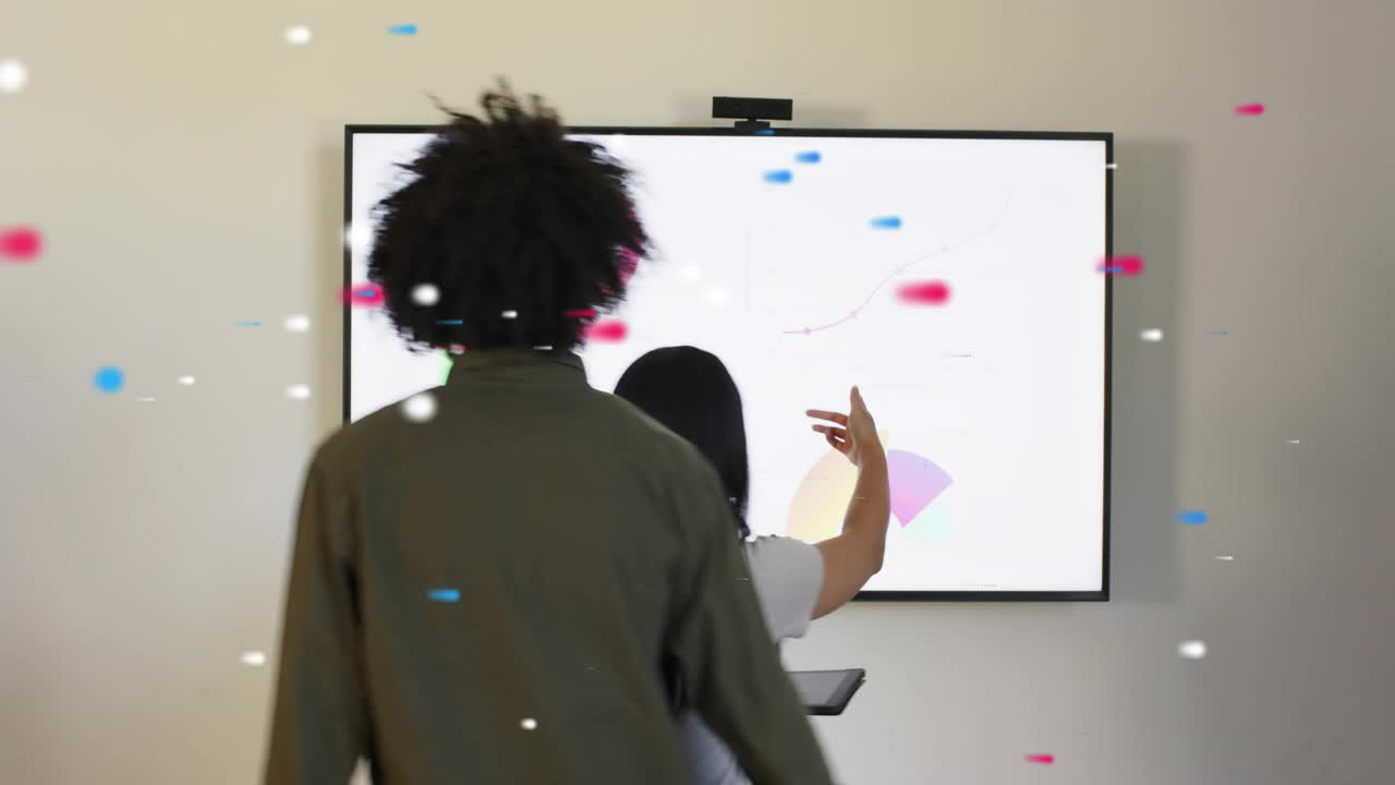 Woman tapping tablet, man reacting in business causing wall screen update and confetti marking win