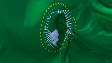 la bandera de la unión africana ondeando en el viento animación en cámara lenta. 4k textura de tela realista bandera soplando suavemente en un día de viento fondo de bucle continuo sin costuras.