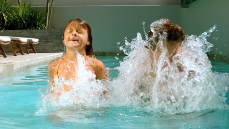 hermanos divirtiéndose en la piscina