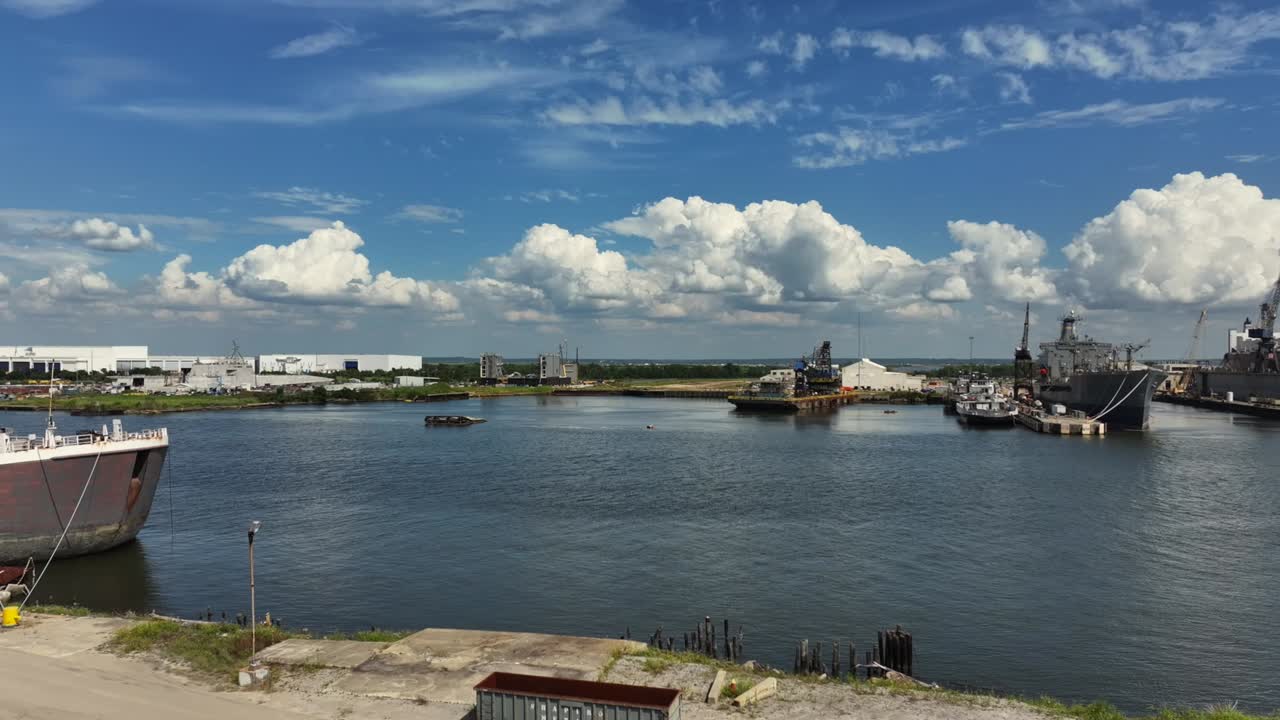 Ships docked at a shipyard under a partly cloudy sky