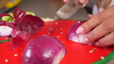 woman chopping red onion for cooking
