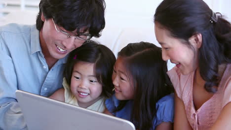 family laughing while using a tablet computer