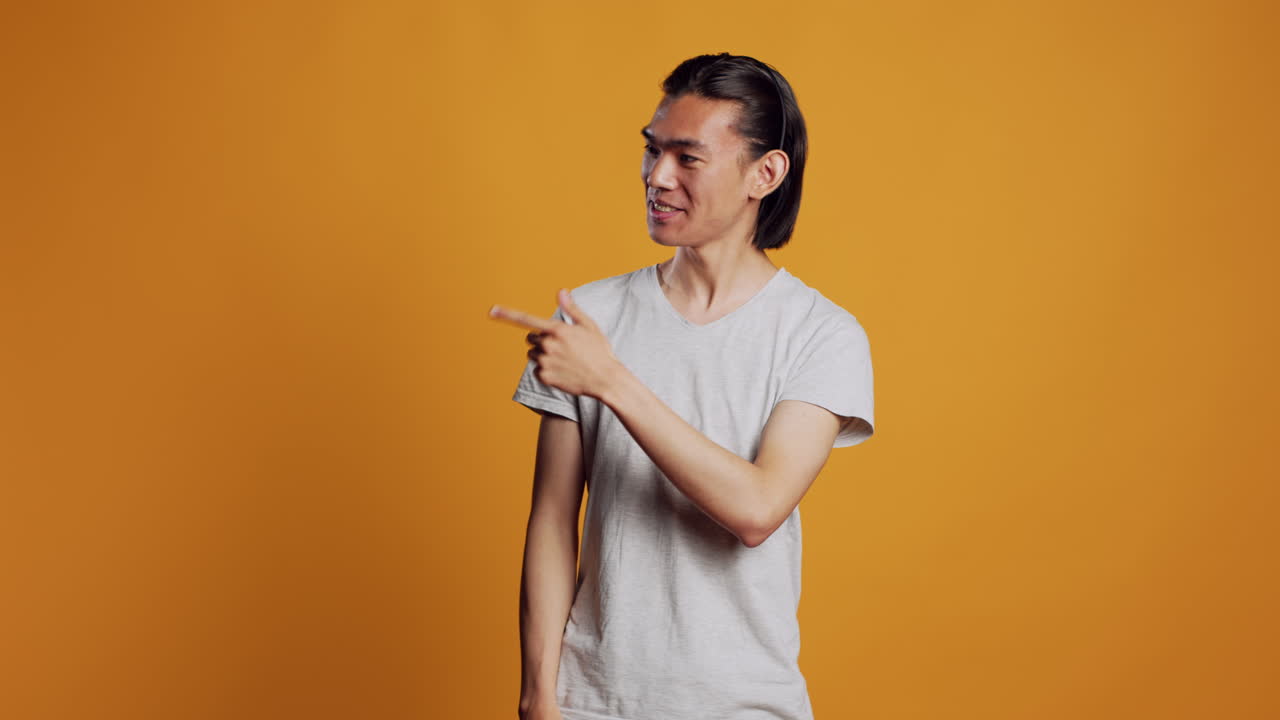 Asian person pointing sideways with index fingers