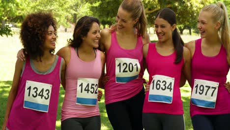 mujer feliz corriendo rosa para la concientización del cáncer de mama en el parque