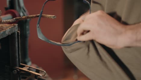 worker grabbing safety goggles from rusty workbench in workshop