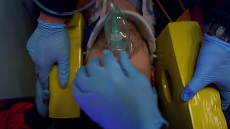 Paramedics-in-gloves-providing-ambulance-help-to-man.-Victim-in-oxygen-mask