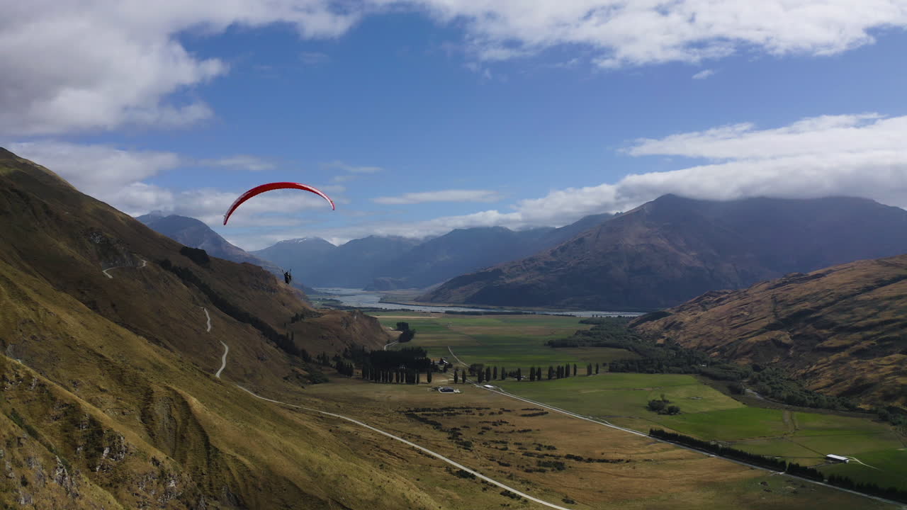 parapente en wanaka nueva zelanda a través de las montañas y colinas con vistas a un hermoso día de verano cerca del valle