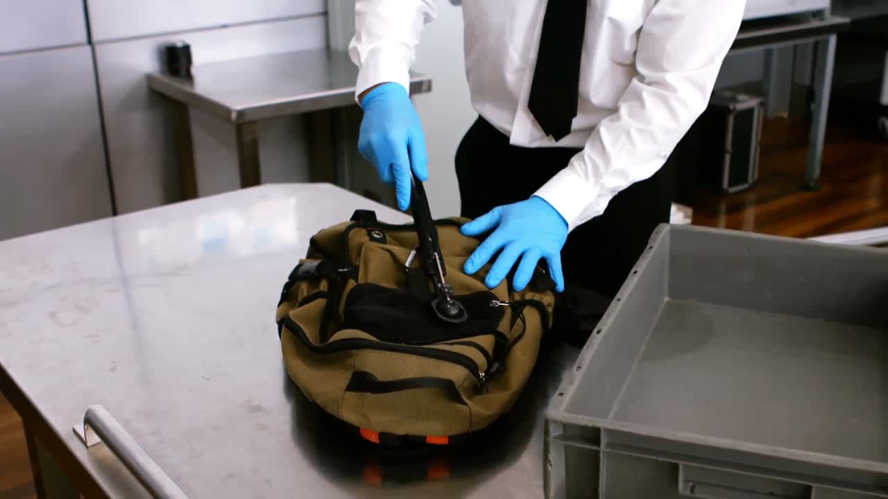 personal de seguridad del aeropuerto usando detector de metales