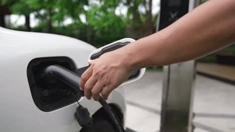 el hombre instaló el cable progresivo en su coche ev desde la estación de carga de su casa.