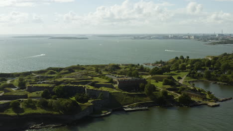 Vista-Aérea-Alrededor-De-La-Isla-Susisaari,-En-El-Sitio-Del-Patrimonio-Mundial-De-La-Unesco-De-Suomenlinna,-Barcos-En-El-Fondo,-Soleado,-Día-De-Verano,-En-Helsinki,-Finlandia---Dando-Vueltas,-Disparo-De-Drones