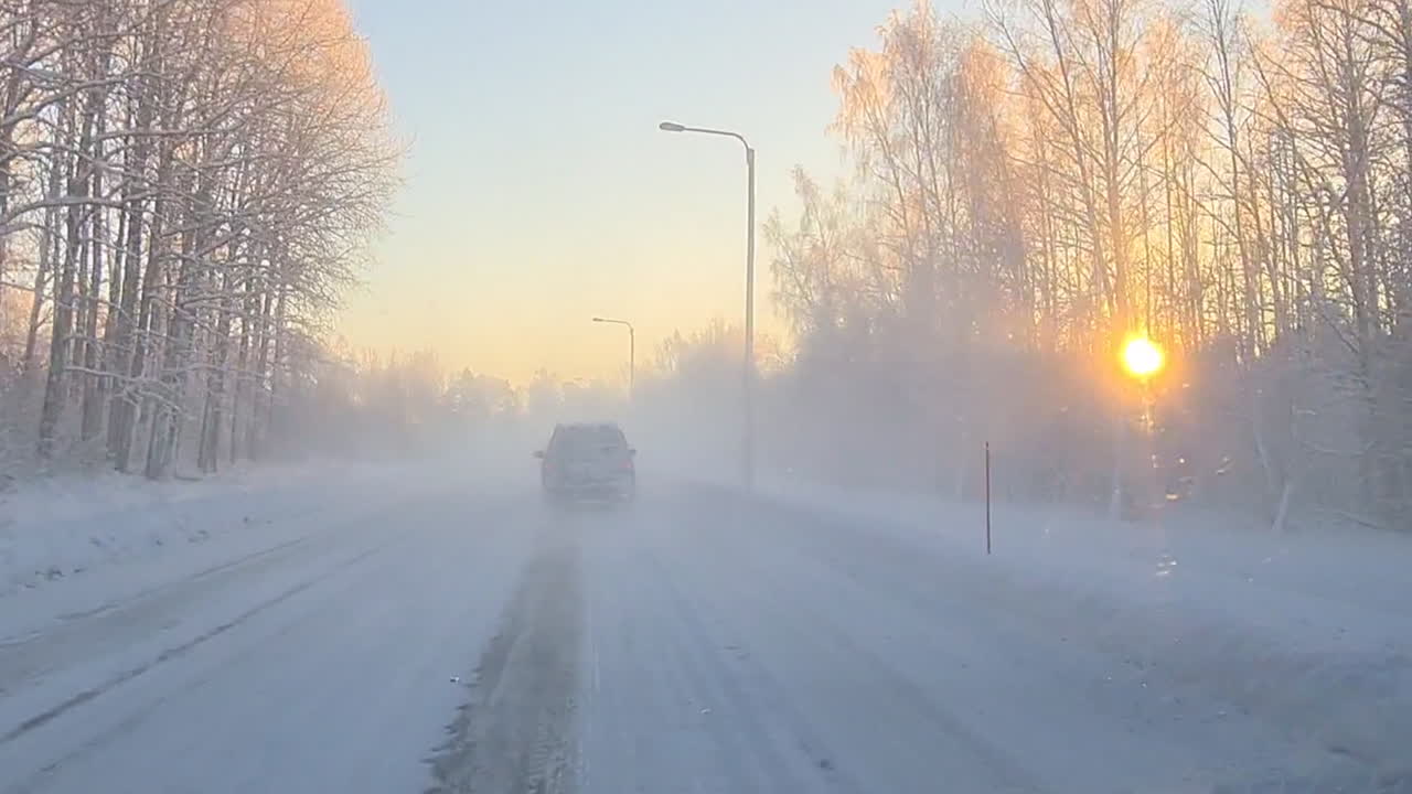 숲속의 눈 덮인 도로를 여행하는 자동차